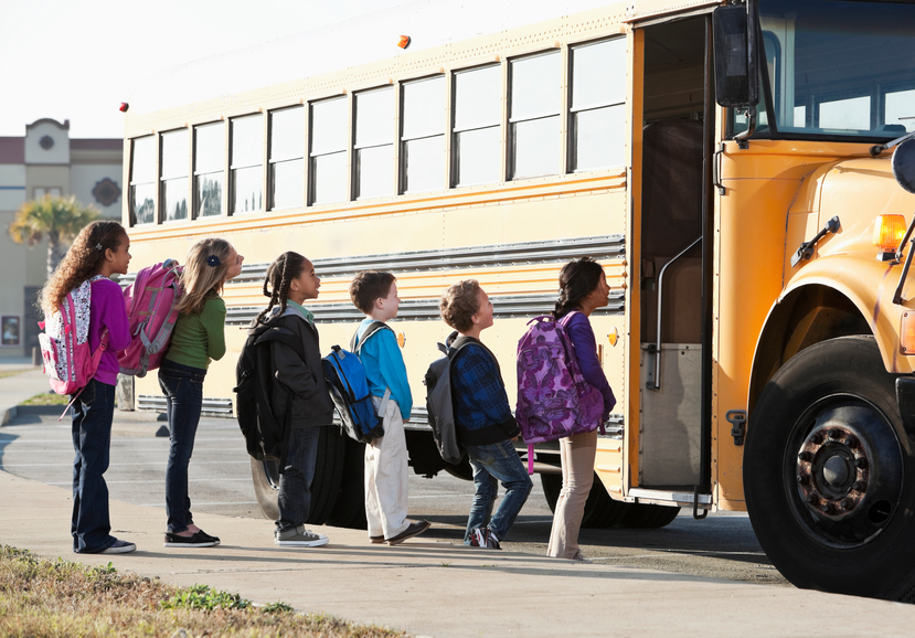 Line of children boarding school bus