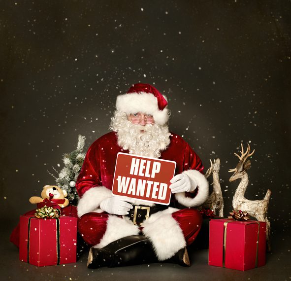 Santa Claus holding Help Wanted sign